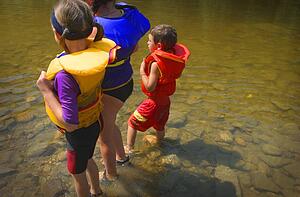 Three children paddling in a lake