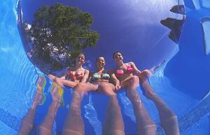 Girls dangling feet in pool