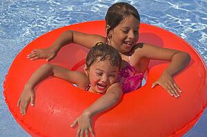 Two girls with rubber ring in pool