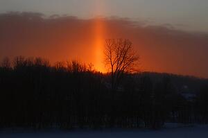 Orange sunset behind a snow covered country town