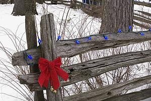 Christmas decorations on an old wooden fence outside in the snow