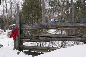 Christmas decorations on an old wooden fence outside in the snow