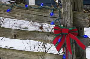 Christmas decorations on an old wooden fence outside in the snow