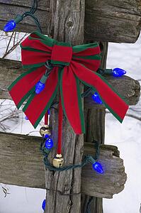 Christmas decorations on an old wooden fence outside in the snow