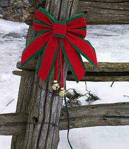 Christmas decorations on an old wooden fence outside in the snow