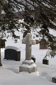 Gravestones in a cemetery covered in snow
