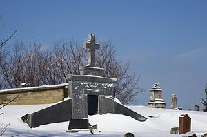 Gravestones in a cemetery covered in snow