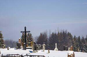 Gravestones in a cemetery covered in snow
