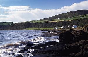 Arran, Scotland, United Kingdom; Houses dotting the rugged coastline, 