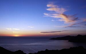 Corsica, France; View across a bay to sunset