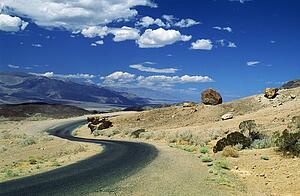 Death Valley, California, USA; Winding road in front of expansive desert