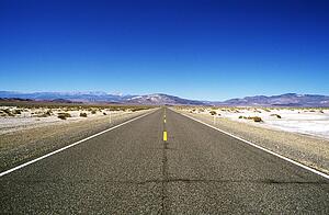 Road leading through barren landscape to mountains