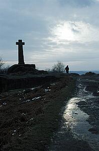 Baslow, Derbyshire, England, United Kingdom; Person walking by a cross monument in a national park