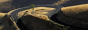 Idaho, USA; Road winding around hilly landscape