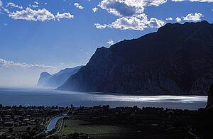 Italy; View across a small town to Lake Garda and cliffs