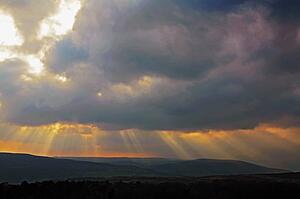 Derbyshire, England, United Kingdom; Sunbeams striking through clouds