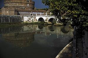 Rome, Italy; Lone kayaker on a river beside an ancient castle