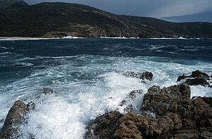 Corsica, France; Waves crashing on a rugged coastline