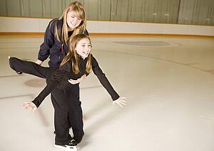 Two girls practicing ice skating together