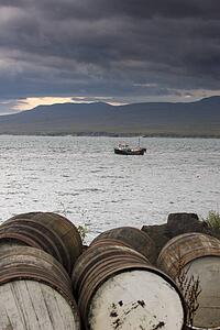 Barrels on the shore, boat in the water