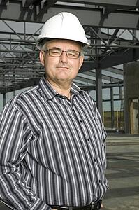 Man in hardhat in partially built building