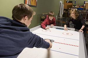 Family playing air hockey