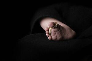 Baby's foot with wedding rings of parents 