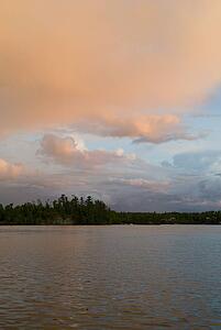 Lake of the Woods, Ontario, Canada; Sunset turning cloud orange over lake