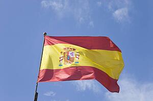 Spanish flag rippling in the breeze against a blue sky