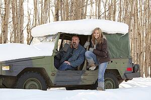 Man and woman in a snow covered vehicle