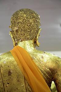 Isan, Thailand; Golden Buddha statue with orange sash