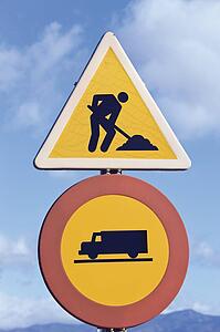 Traffic signs; Men at work and no entry for trucks traffic signs