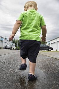 Boy walking in a puddle