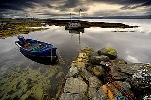 Islay, Scotland; Two boats anchored by a beach