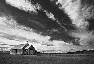 Small country church in grass field in black and white