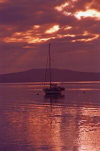 Sailboat at anchor with cloudy evening