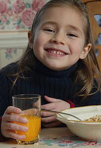 Young girl with food at breakfast table