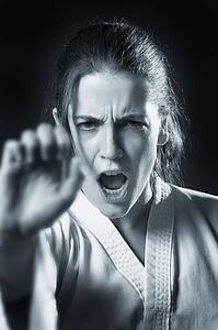 woman doing a karate punch in black and white