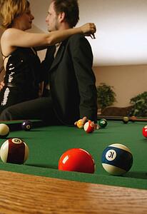 Couple embraces by pool table