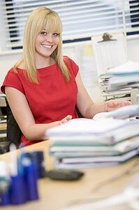 Woman sitting happily at her desk