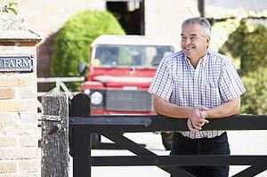 Farmer Looking Over Farm Gate