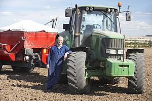 Driver Standing In Front Of Tractor