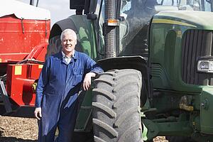 Driver Standing In Front Of Tractor
