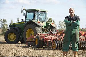 Driver Standing In Front Of Tractor