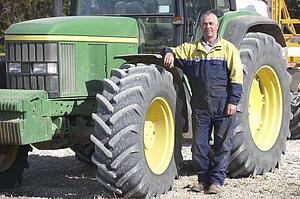 Driver Standing In Front Of Tractor