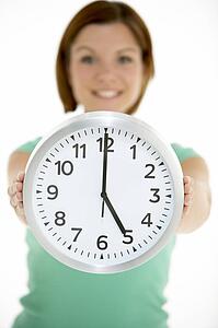 Woman Holding Clock Showing 5 O'Clock