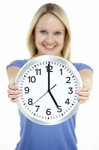 Woman Holding Clock Showing 5 O'Clock