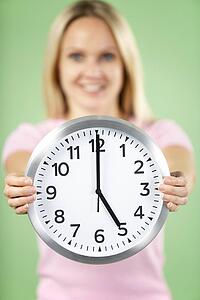 Woman Holding Clock Showing 5 O'Clock