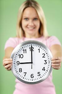 Woman Holding Clock Showing 9 O'Clock