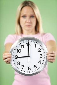Woman Holding Clock Showing 9 O'Clock